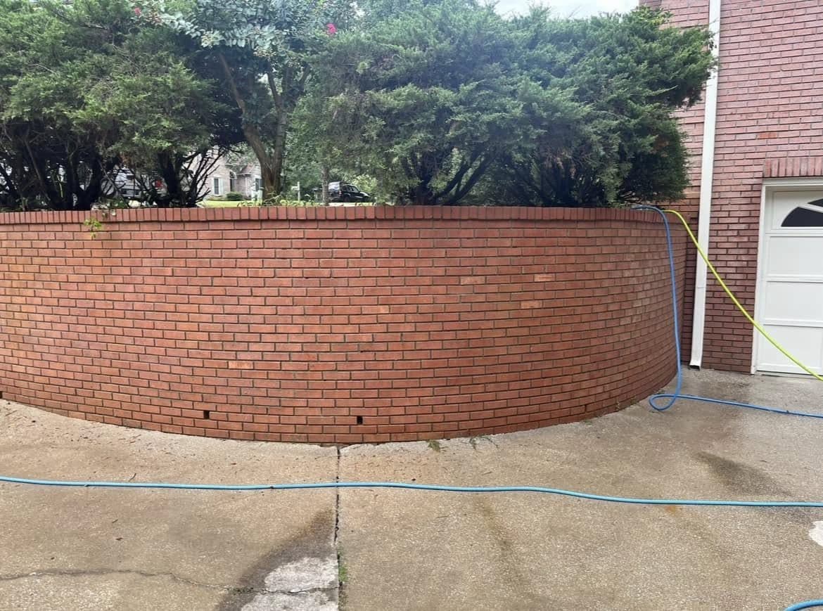 Curved brick retaining wall and the concrete below it after cleaning, Birmingham metro