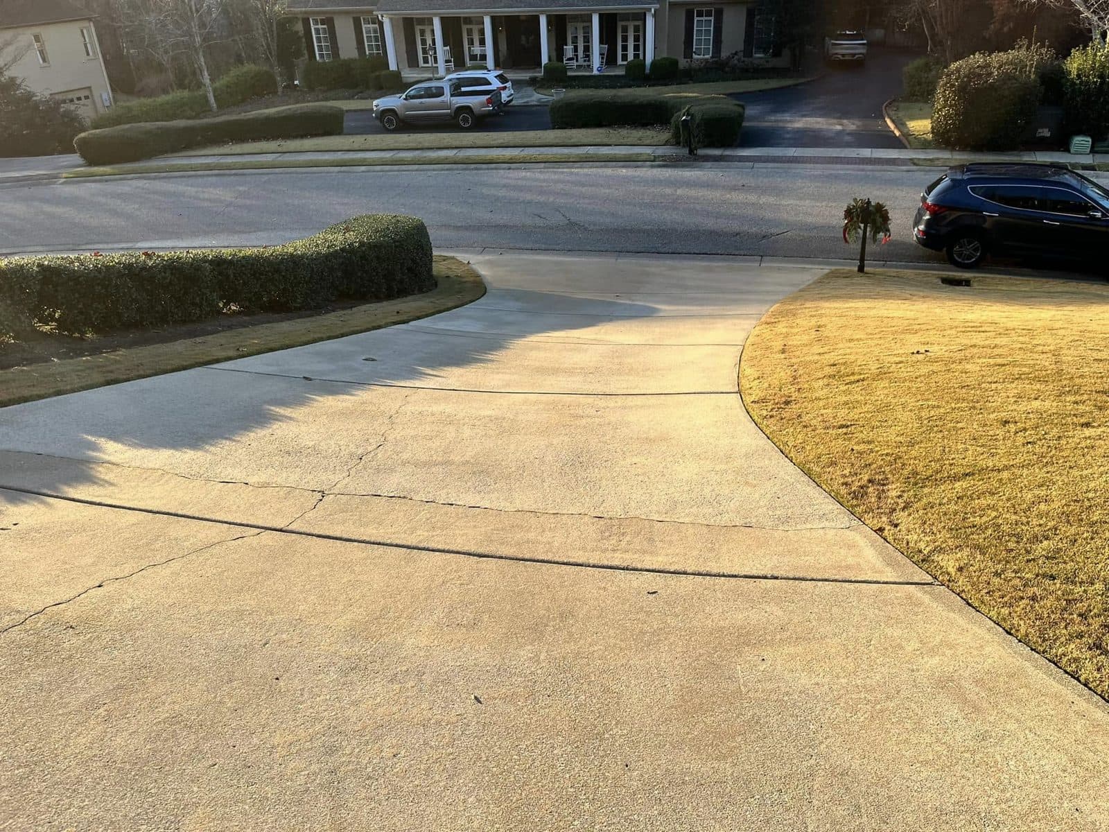 Long curved concrete driveway after cleaning, stone front home, Birmingham metro