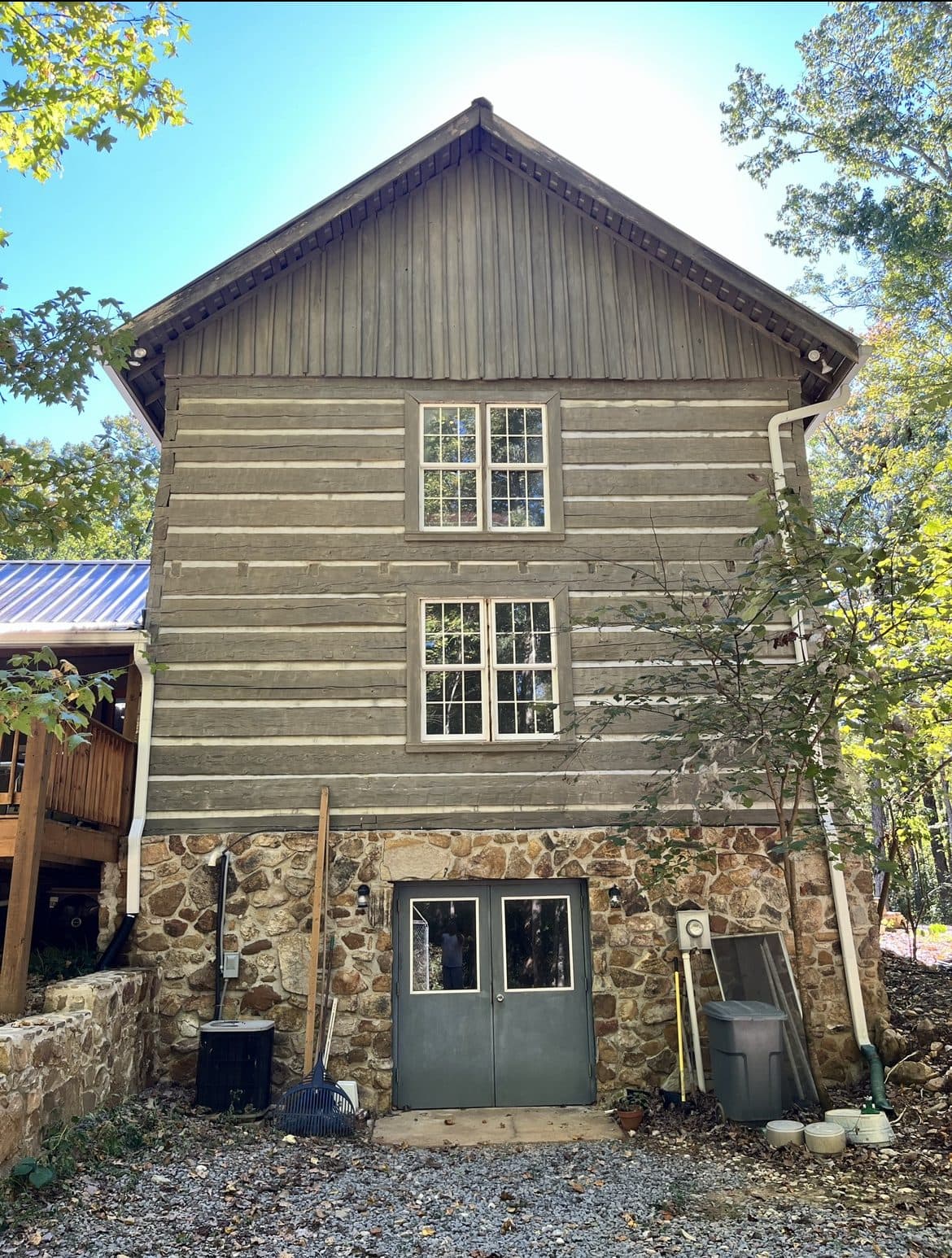 Log sided home with a stone base after an exterior wash, Birmingham metro